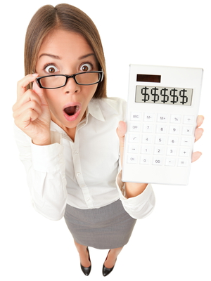 Business woman accountant shocked showing dollar signs on calculator. Surplus, debt or financial crisis concept image. Funny surprised young woman isolated on white background in high angle view.